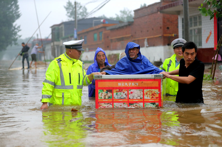 7月22日，河南省公安廳高速交警總隊民警在新鄉衛輝黃庄暴雨嚴重地區救助被困群眾。楊軍政攝 