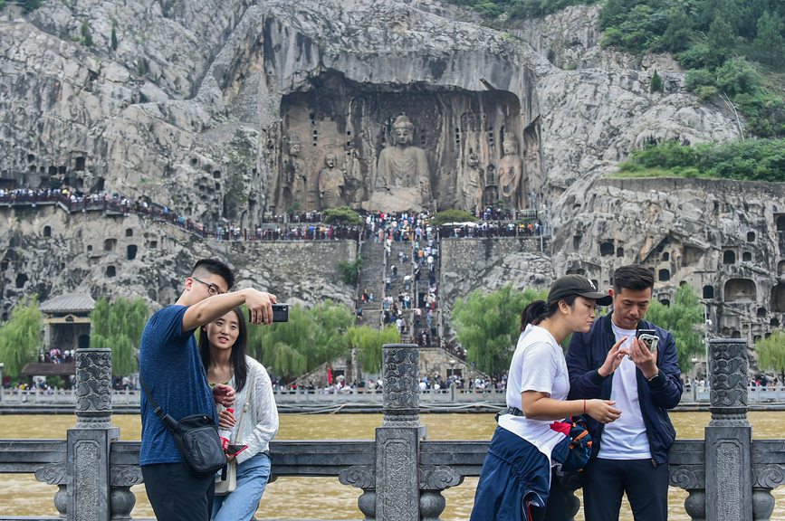 近日，游客在参观游览世界文化遗产洛阳龙门石窟，感受千年石窟文化，享受休闲假期。黄政伟摄