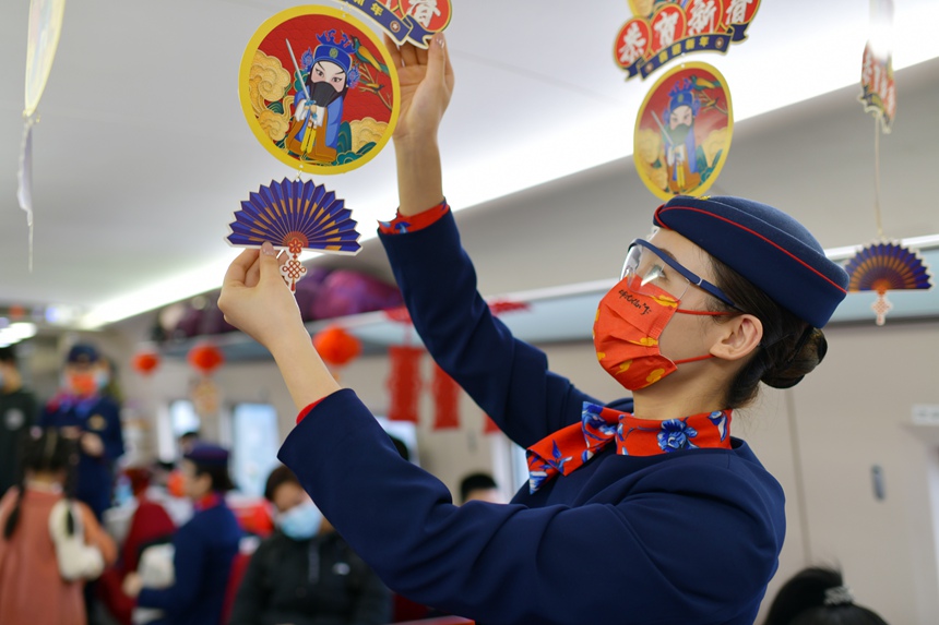 G1576次列車上，列車員正在裝飾車廂，營造喜慶的節日氛圍。閆波攝