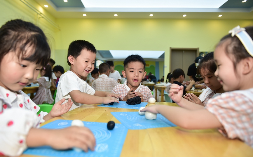 小朋友们学习制作手工月饼。黄政伟摄