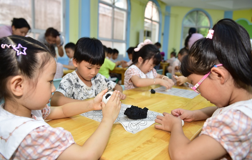 小朋友们学习制作手工月饼。黄政伟摄