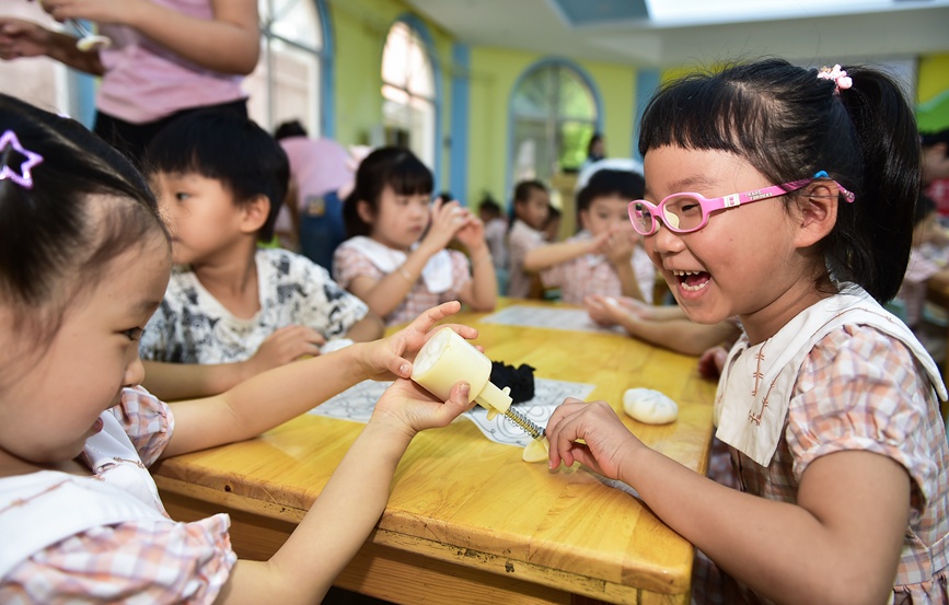 小朋友们学习制作手工月饼。黄政伟摄