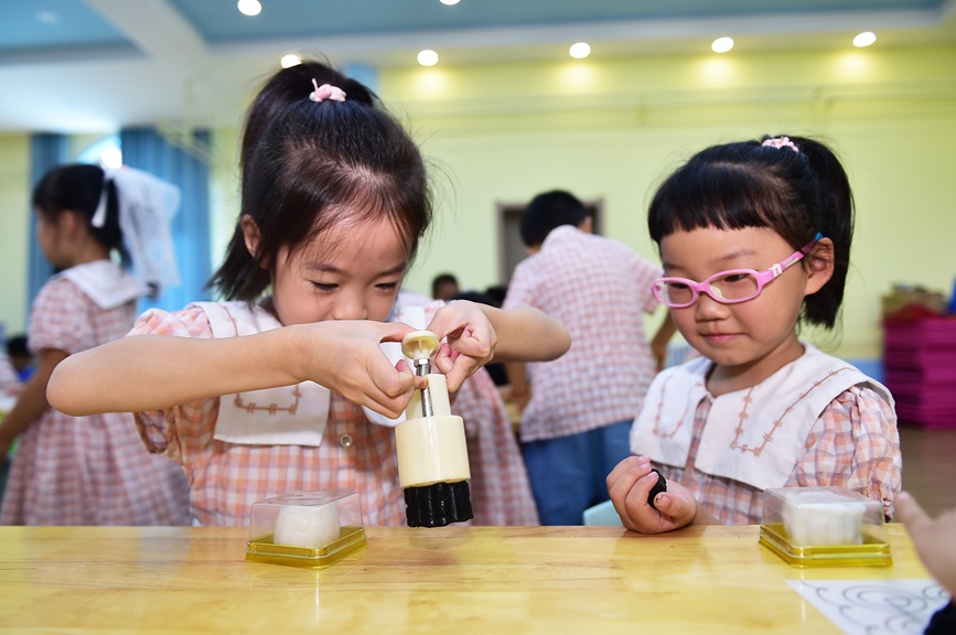 小朋友们学习制作手工月饼。黄政伟摄