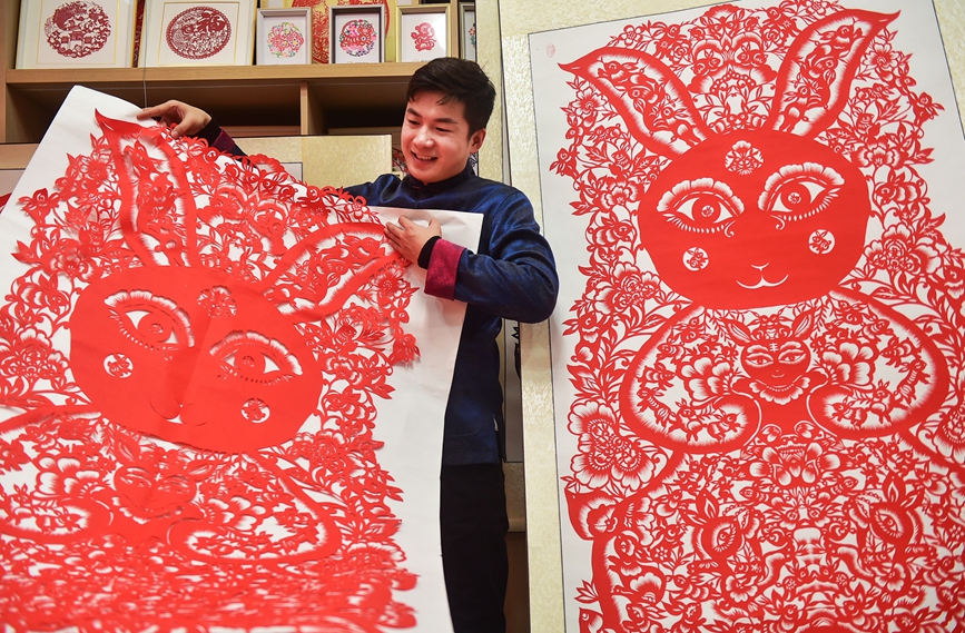 “90后”非遗传承人畅杨杨展示自己创作的“百兔闹春”主题剪纸作品。黄政伟摄
