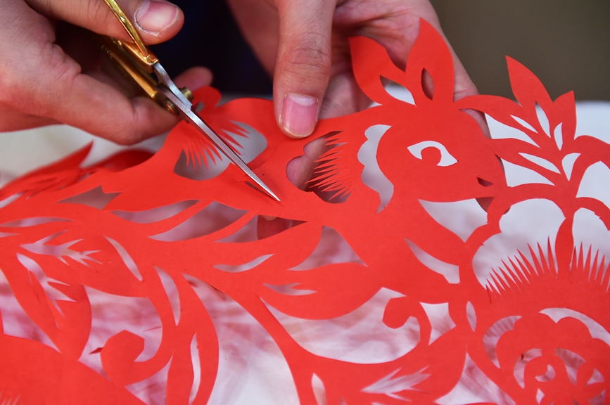 “90后”非遗传承人畅杨杨展示自己创作的“百兔闹春”主题剪纸作品。黄政伟摄 