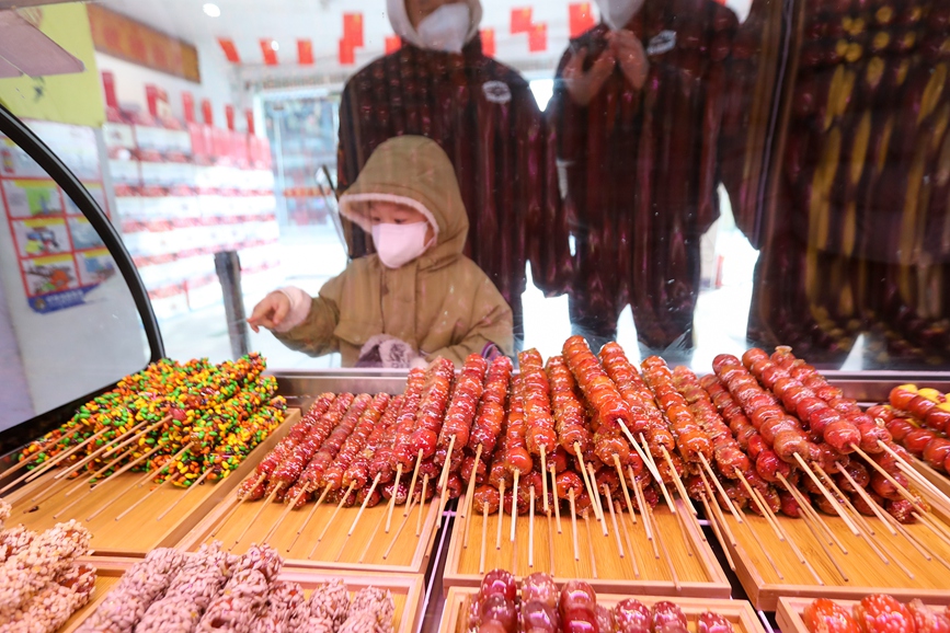 游客在河南省商丘市百年老字号“归德胖嫂”购买糖葫芦。李恒摄