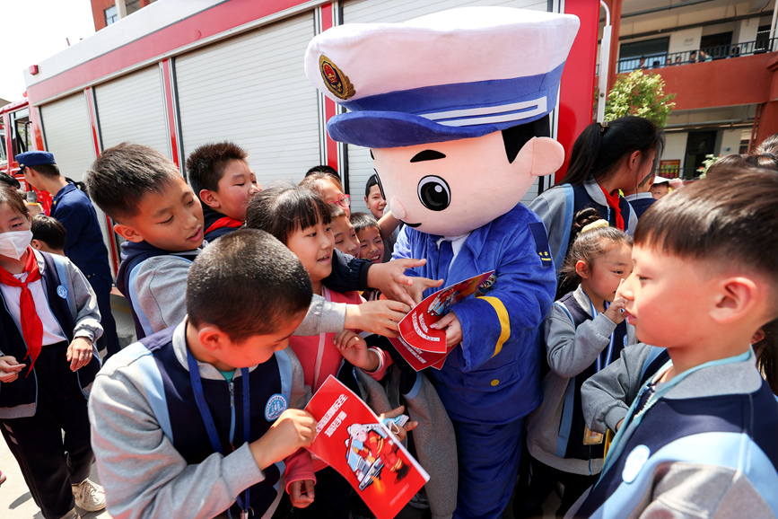 5月8日，河南省济源市消防救援支队宣传人员向孩子们发放宣传材料。张步高摄