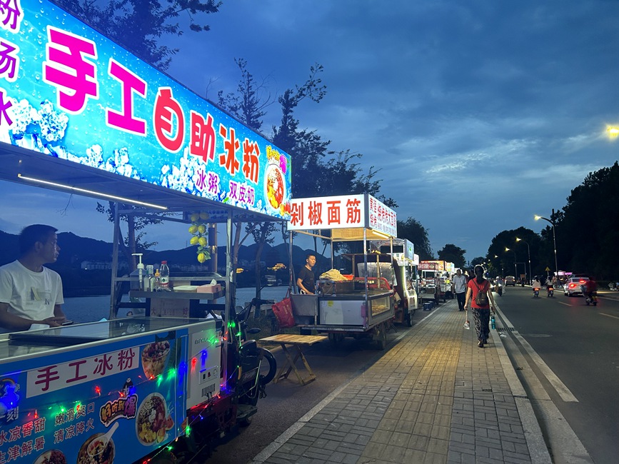 夜幕降临，浉河夜经济焕发出新鲜的活力。图为浉河岸边夜市摊位。徐铭摄