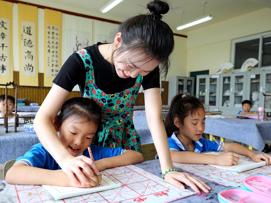 7月13日，安陽市高新區銀杏南校書法暑期延時服務課，老師正在指導學生練字。麻翛然攝