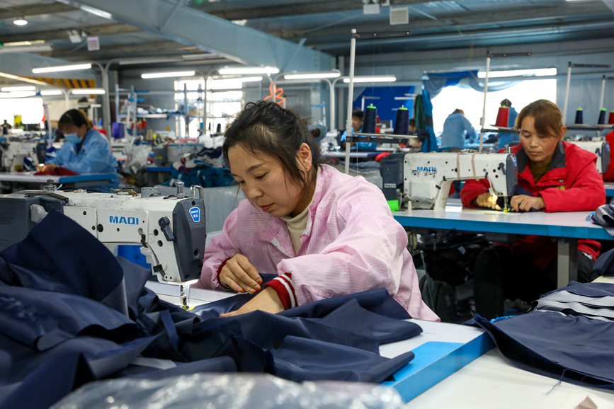工人们在濮阳市清丰县六塔乡浩善实业有限公司生产车间里，缝制、修剪服装。清丰县委宣传部供图