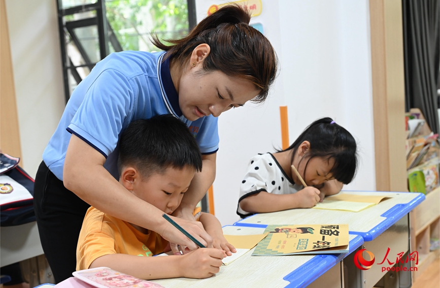 輔導孩子書法。人民網記者 王玉興攝