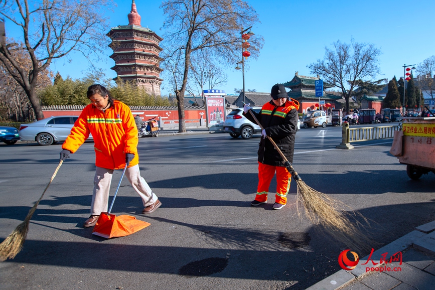 1月29日，安阳市环卫工刘仙芬与同事师秋红在文峰中路清扫人行道。人民网 辛静摄