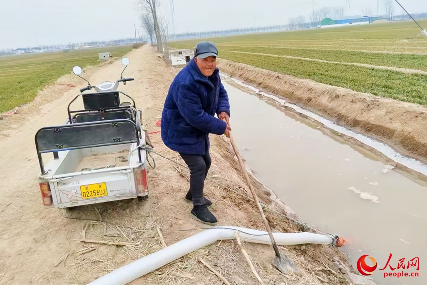 河南省封丘縣魯崗鎮康寨村村民石秀業在田間澆麥子。人民網 程明輝攝