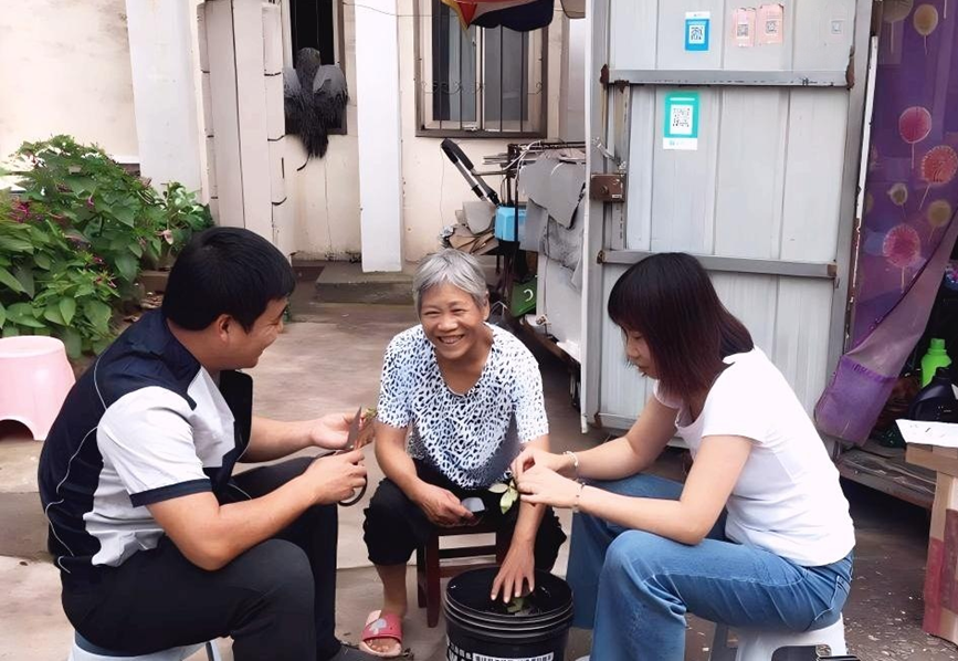 司送人员在乡村小店边帮零售客户干农活边征询送货服务需求。河南省烟草公司三门峡市公司供图