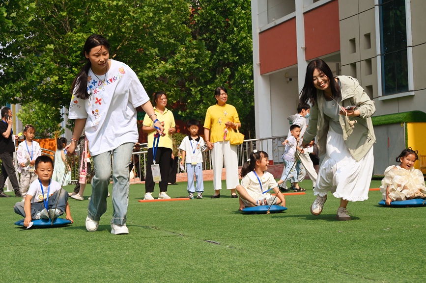 5月28日，河南省南陽市社旗縣第三幼兒園舉辦“雙節同慶 童心‘粽’在”親自游園活動，家長和孩子們在玩同舟共濟游戲。申鴻皓攝
