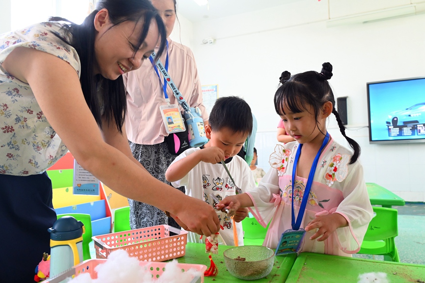 5月28日，河南省南陽市社旗縣第三幼兒園舉辦“雙節同慶 童心‘粽’在”親自游園活動，家長和孩子們在制作香囊。申鴻皓攝