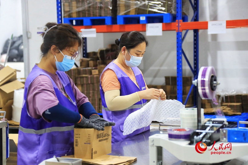 仓储车间里，工作人员正在忙碌中。人民网 霍亚平摄