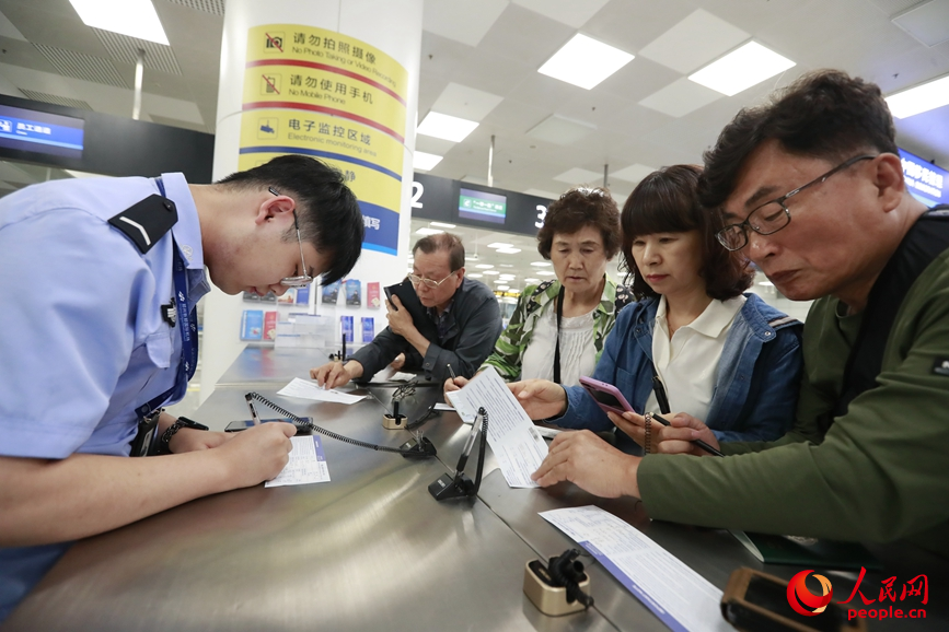旅客在填写入境信息。人民网 霍亚平摄