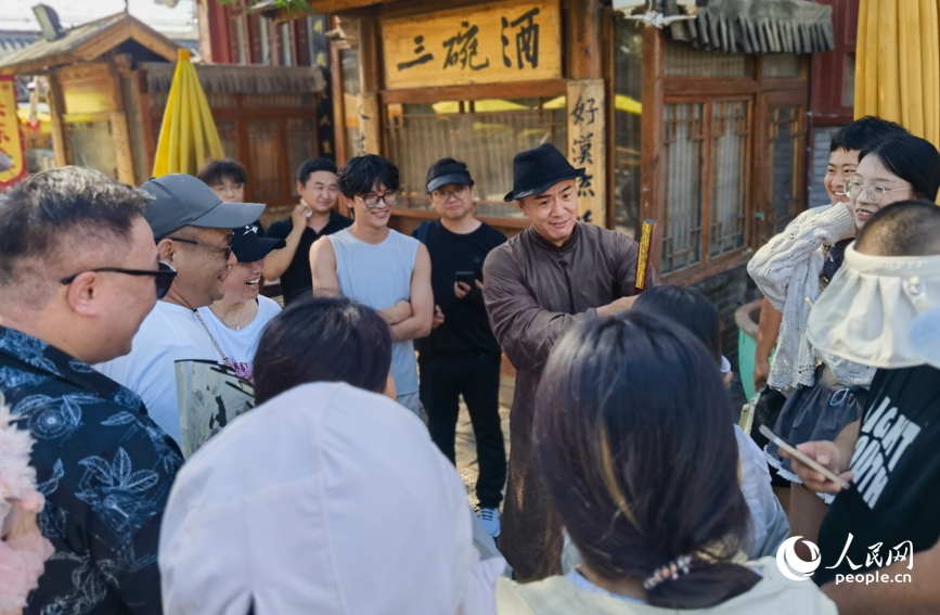 萬歲山武俠城景區，演員與游客成語接龍，互動熱烈。人民網記者 尚明楨攝