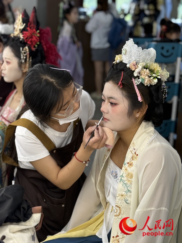 妝造師正在給游客做妝造。人民網記者 王佩攝