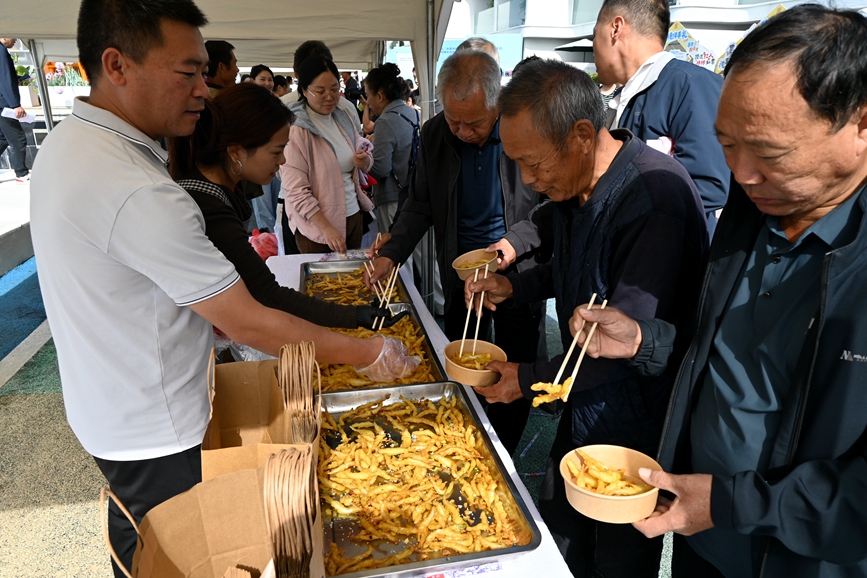 游客品尝鱼宴美食。王艺茜摄