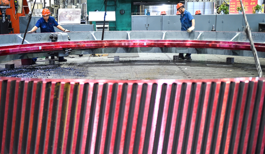 河南省洛阳市的中信重工机加车间内，工人正在起吊加工出口海外的矿业装备磨机齿圈产品订单。黄政伟摄