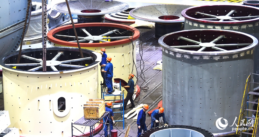 河南省洛阳市的中信重工装配车间内，工人正在起吊装配出口海外的矿业装备磨机筒体产品订单。人民网尚明桢 摄