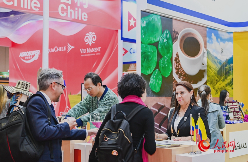 第十八届中国—拉美企业家高峰会展示区，双方代表驻足洽谈。人民网记者 宋芳鑫摄