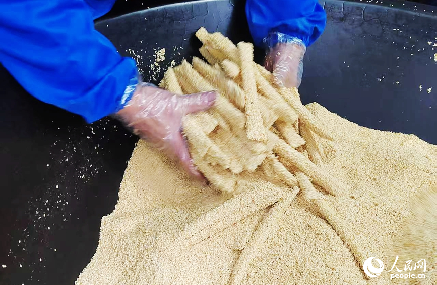给麻糖裹上满满的芝麻。人民网记者 尚明桢摄