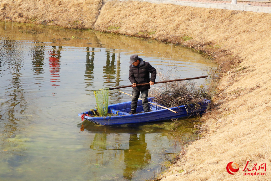 村民打捞坑塘中的垃圾。人民网记者 于思远摄