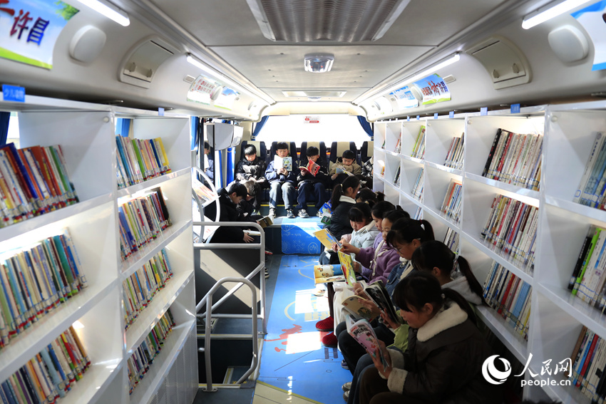 孩子们在图书车上阅读。人民网记者 慎志远摄