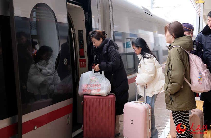 旅客们带着行李，有序登上列车。人民网记者 常力元摄