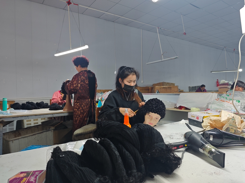 图为周沟村假发制作厂工人正忙碌制作假发。张海山摄