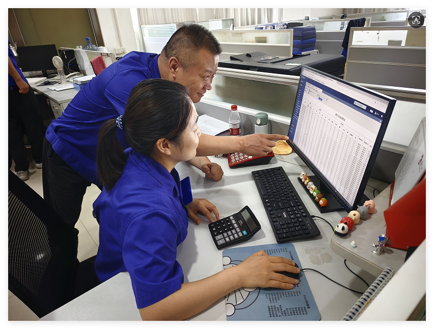 圖為企業能源技術員和生產計劃管理員討論薄片車間日耗電情況。李飛杭攝