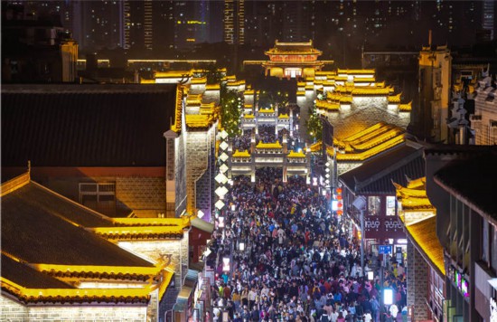 4月17日,湖北襄阳古城北街在霓虹灯的映衬下魅力尽显,人们踏着夜色欣赏古城风貌。