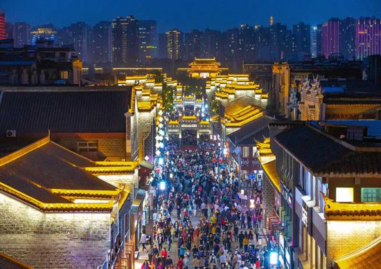 4月17日,随着夜幕降临,湖北省襄阳古城北街和临汉门亮起霓虹灯,吸引了众多市民和游客到古城游玩。