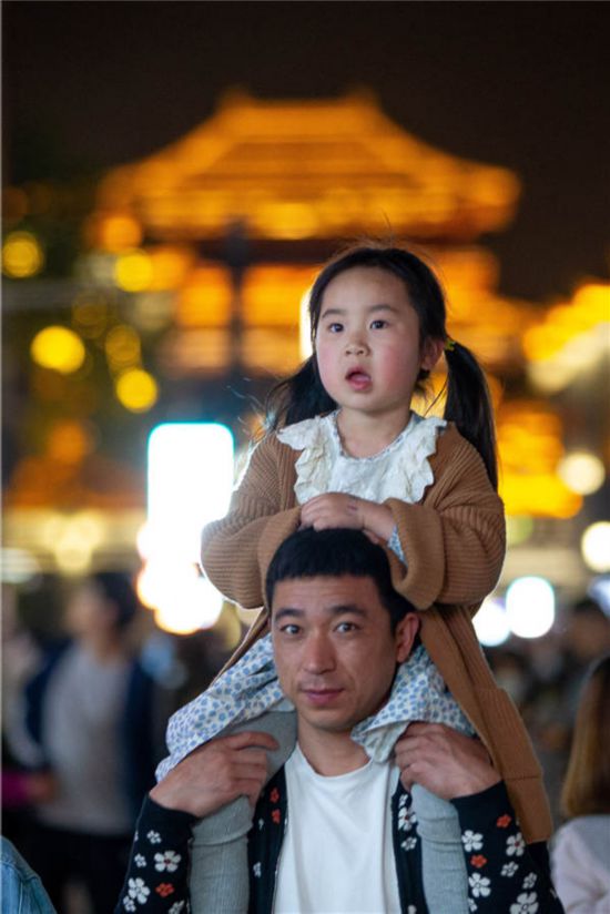 4月17日,游人带着孩子在湖北省襄阳古城北街游玩。